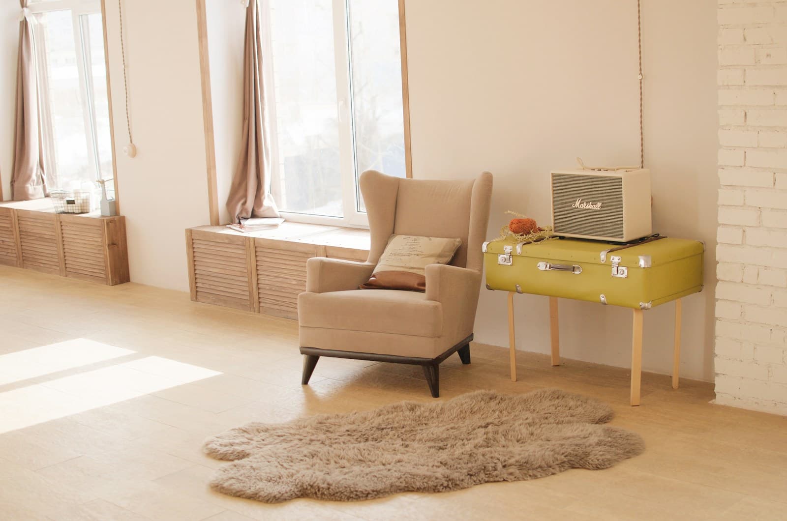 A wing chair and radio in a sunlit interior.