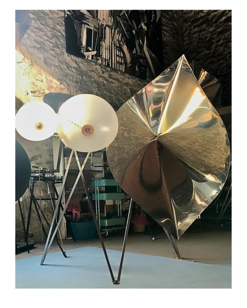 A Grand Cristal Baschet with broad metallic and pale acoustic resonators inside a stone-walled space.
