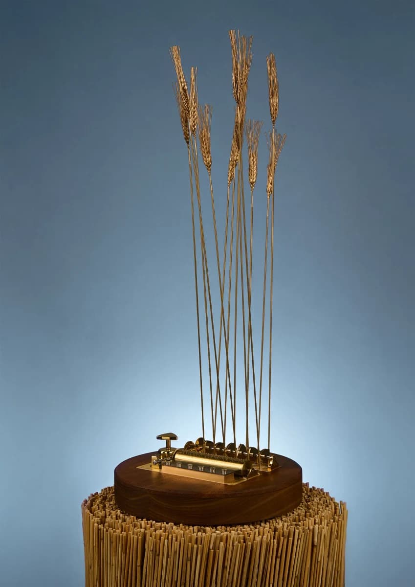 Reuge Slightly Windy with tall golden wheat stalks rising from a wooden mechanical base.
