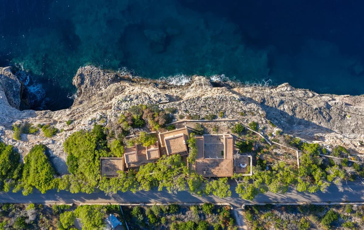 Can Lis seen from above between a rocky Mallorcan coastline and the road.