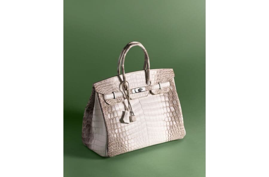 A pale Hermès handbag photographed against a muted green background in Christie’s September press image.