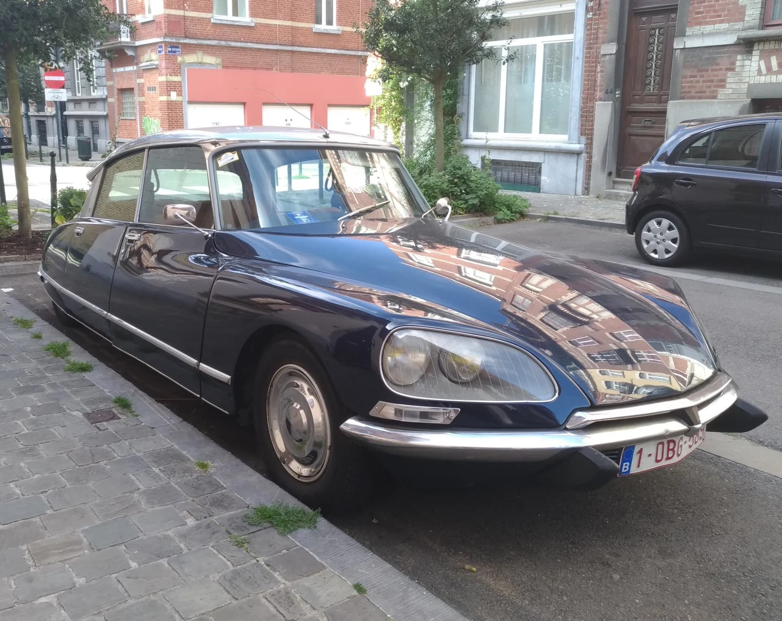 A dark blue Citroën DS 21 Pallas parked on a cobbled street, seen from the front quarter.