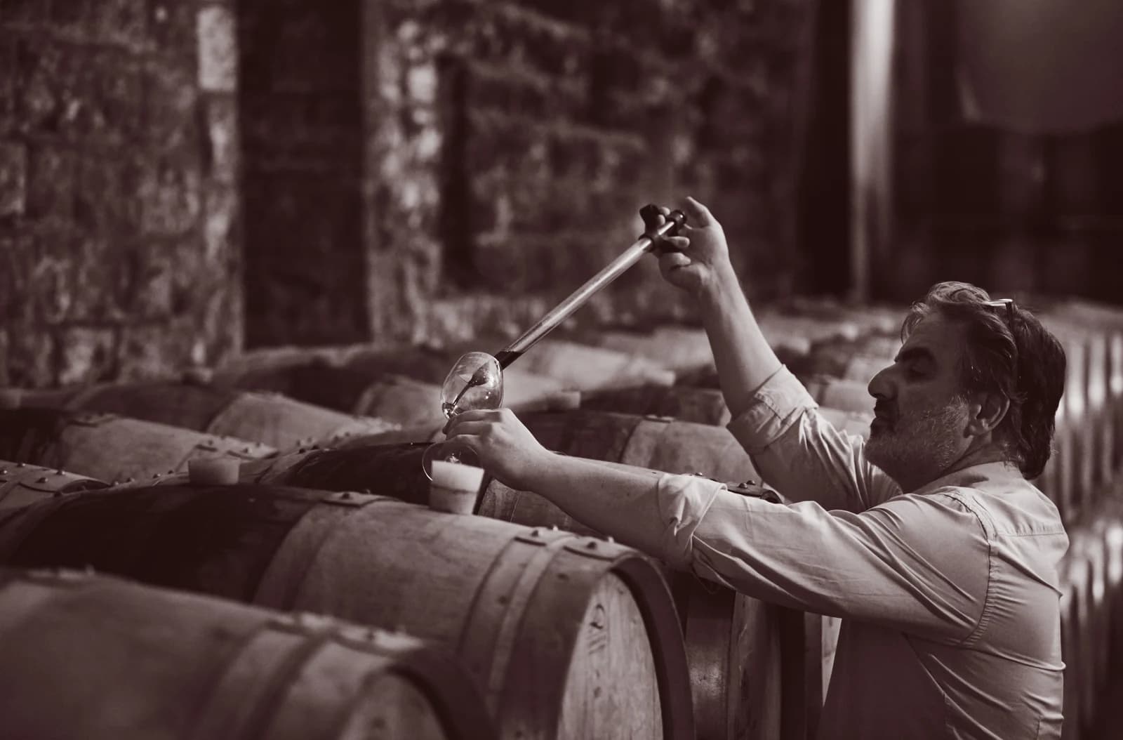 Château Musar winemaker Tarek Sakr samples a glass of wine from a barrel in the cellar.