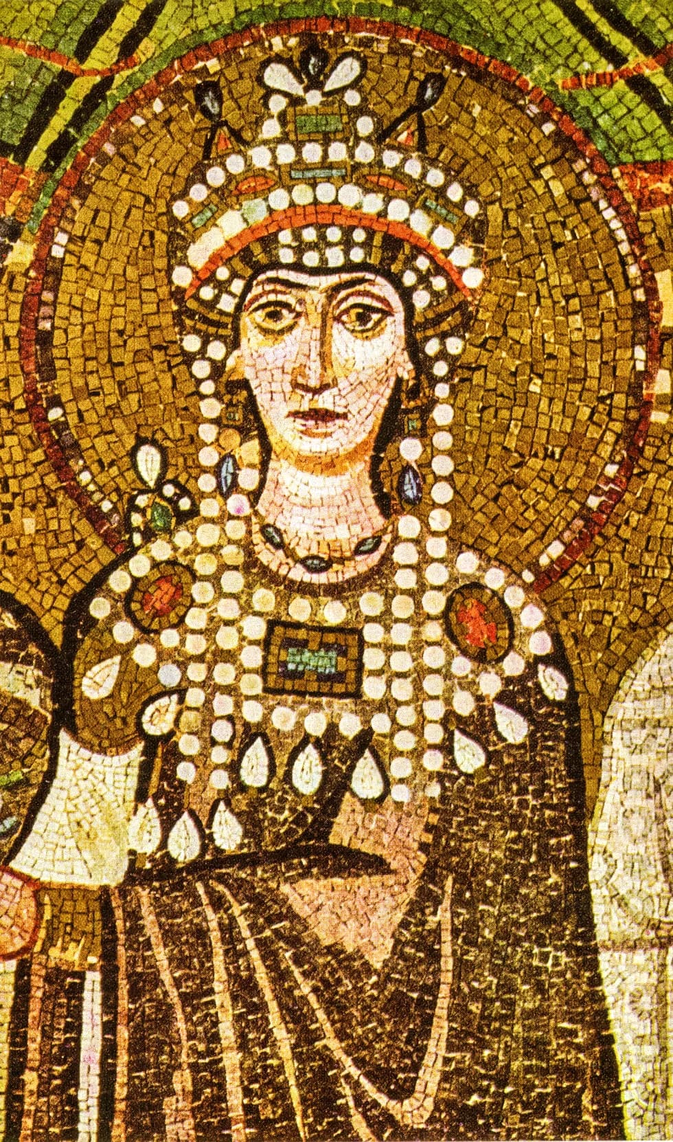A historical mosaic detail of Empress Theodora at San Vitale in Ravenna, with a gold halo, jewelled crown and patterned ceremonial clothing.