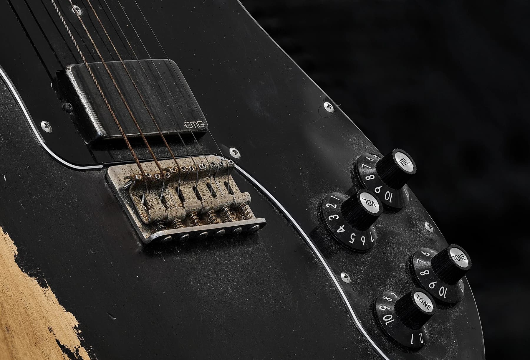 Close detail of a black Fender Custom Shop Telecaster showing an EMG humbucker, bridge, worn finish and metal controls.