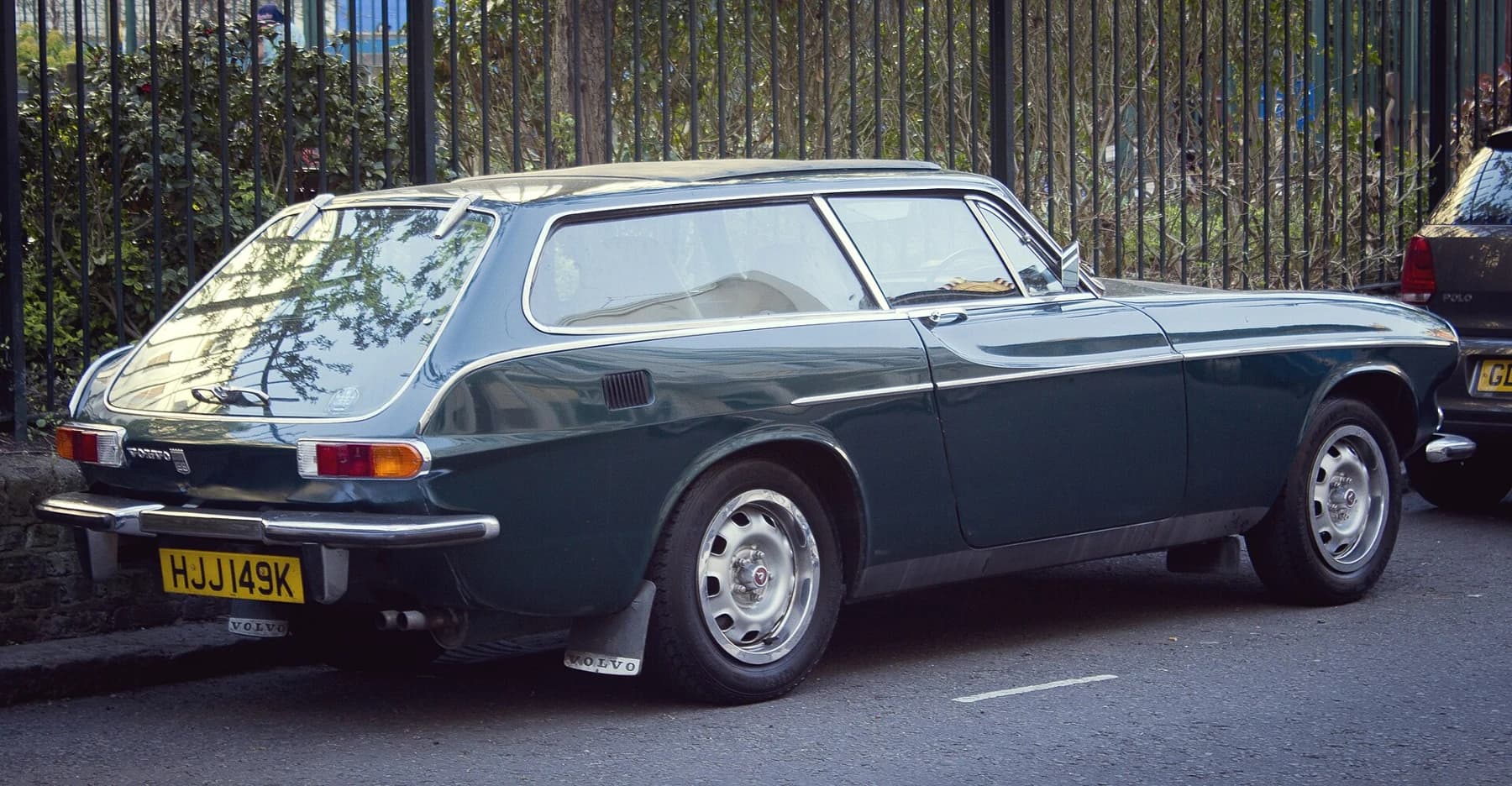 A dark blue Volvo 1800ES seen from the rear quarter, showing its long roof, glass tailgate and compact sporting body.