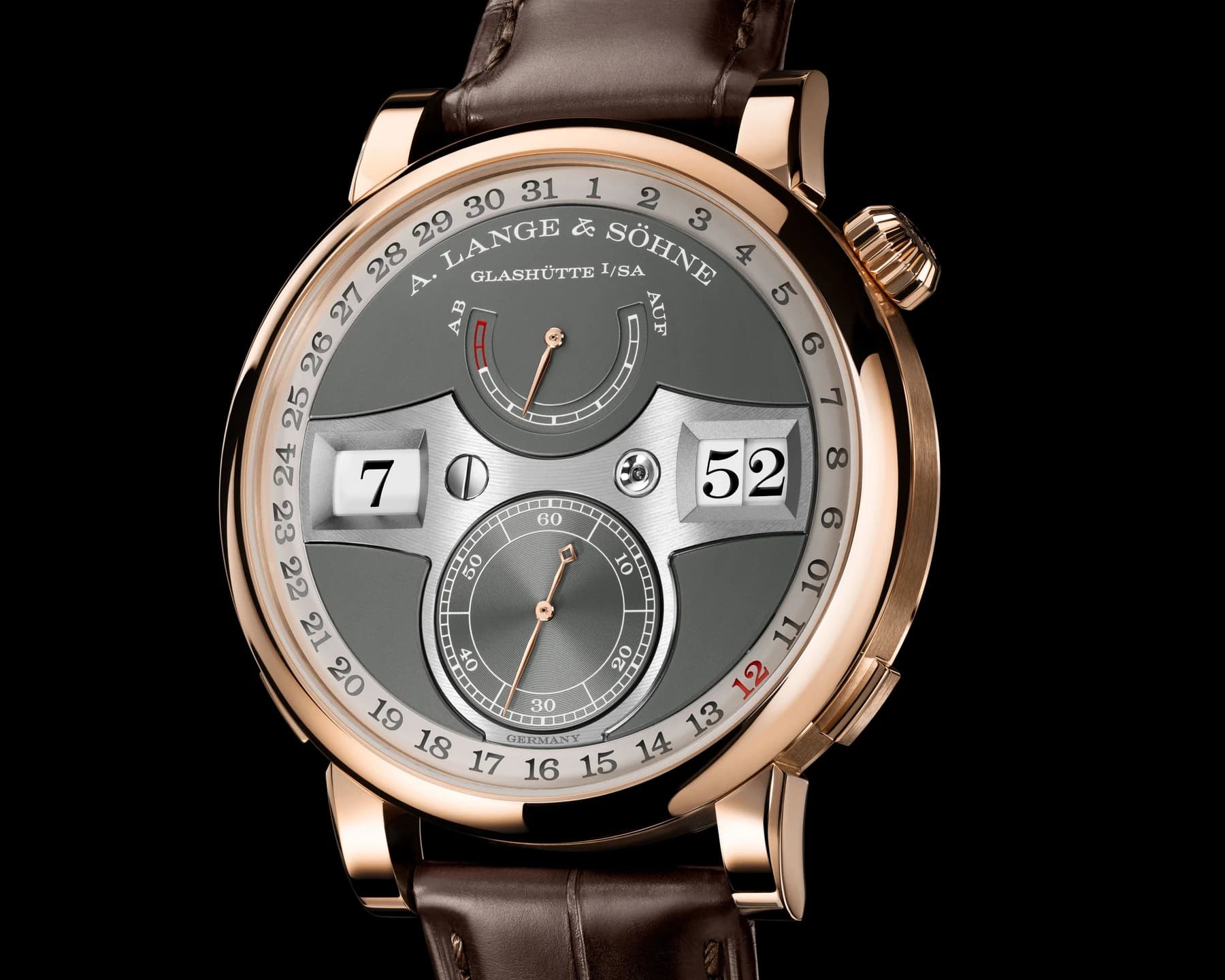A pink-gold A. Lange & Söhne Zeitwerk Date with grey dial, separate hour and minute numeral windows and a peripheral date ring on a brown strap.