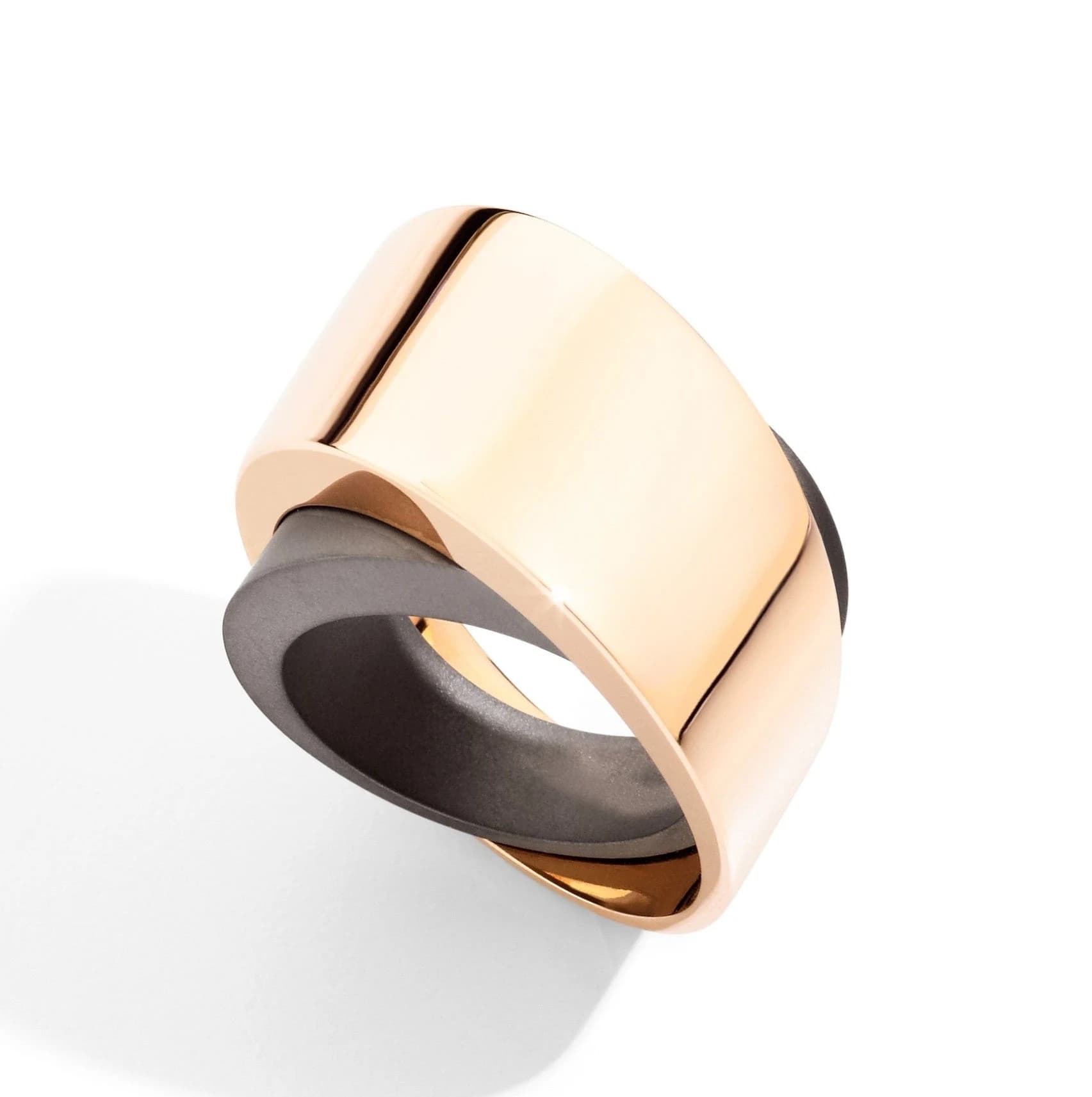 Vhernier Tourbillon Midi ring with a broad polished rose-gold curve crossing a dark titanium surface against white.