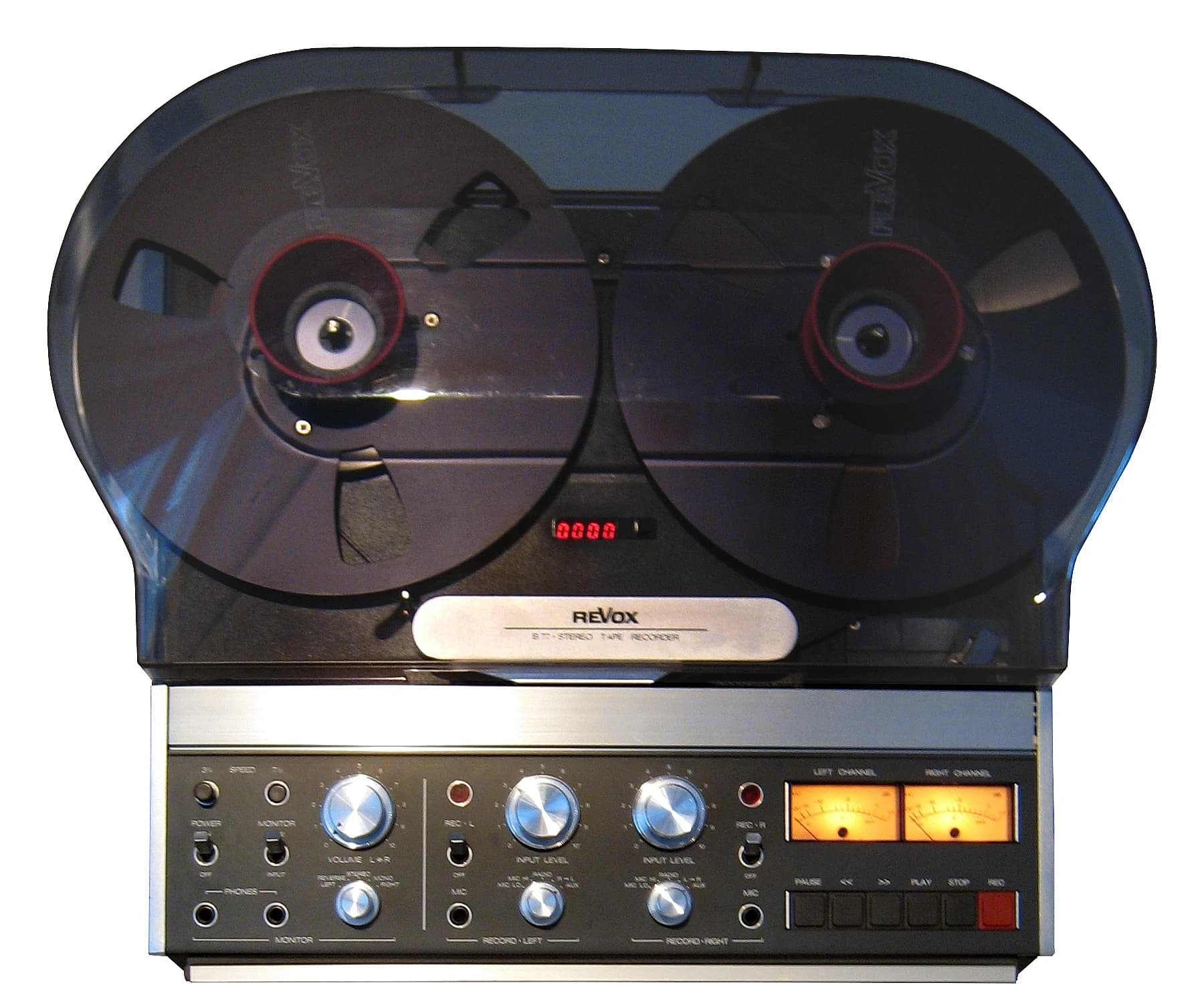 An early Revox B77 reel-to-reel tape recorder seen from the front, with two reels beneath a tinted protective cover and physical recording controls below.