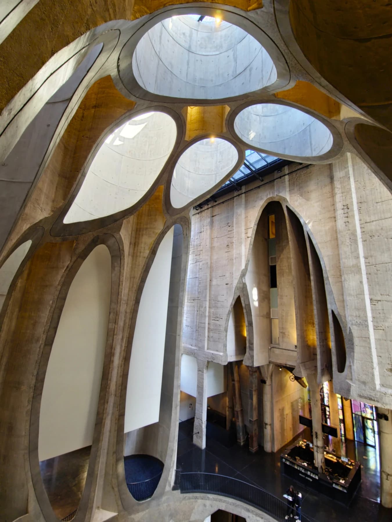 The tall atrium of Zeitz MOCAA in Cape Town, with intersecting curved concrete silo walls, cut edges and daylight entering through the openings above.