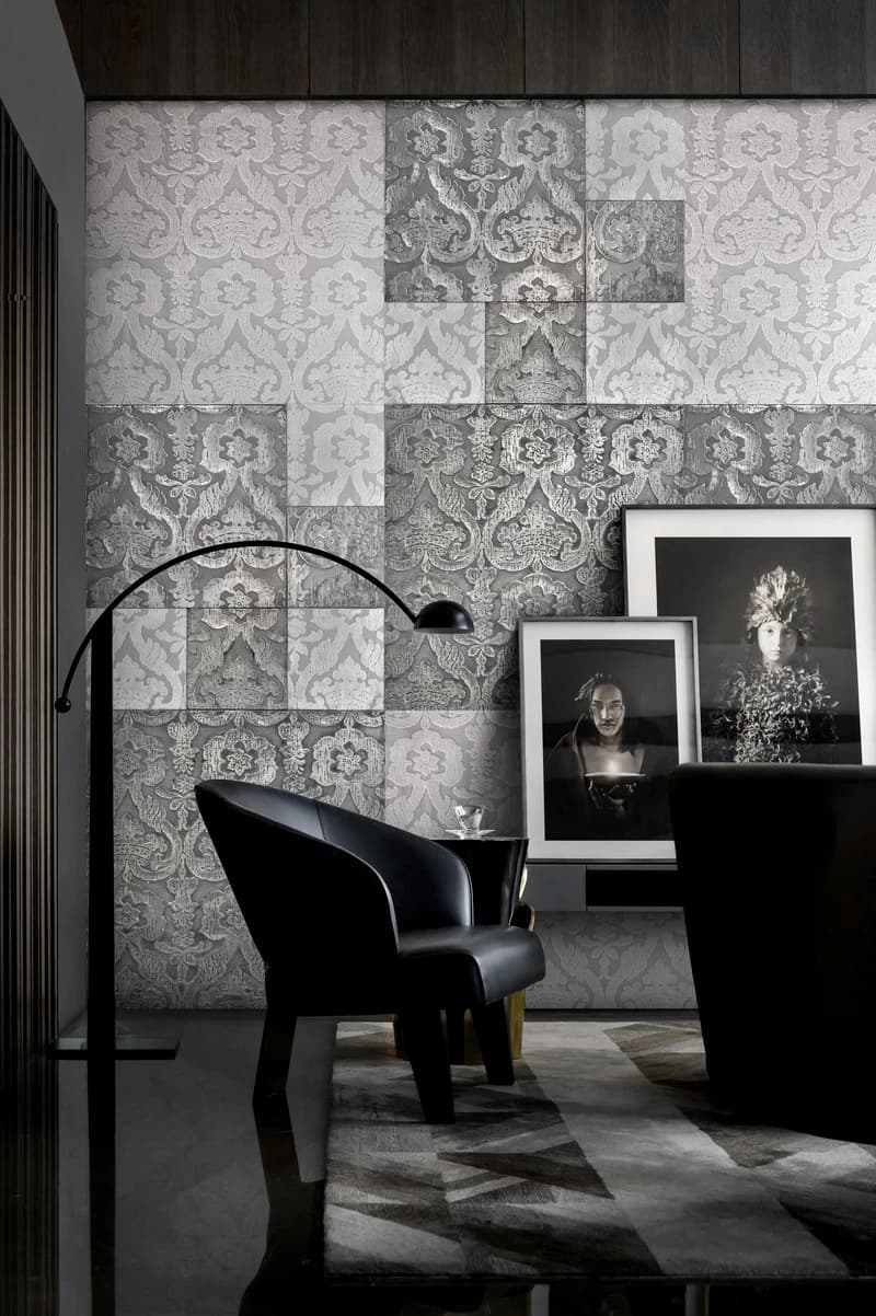 A supplied dark interior view featuring Levantina wall panels with alternating ornamental velvet and metallised textile areas behind a sculptural chair and framed works.