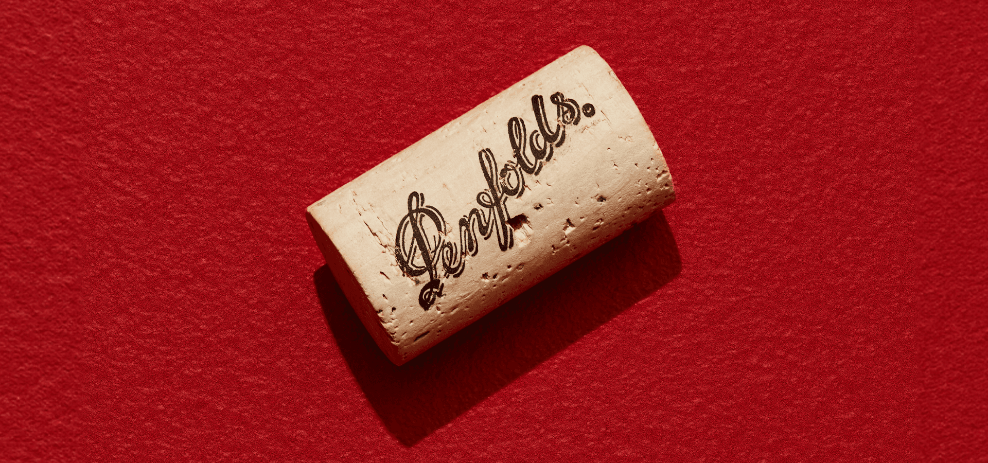 A close view of a wine cork resting on deep red cloth in Penfolds recorking programme imagery.