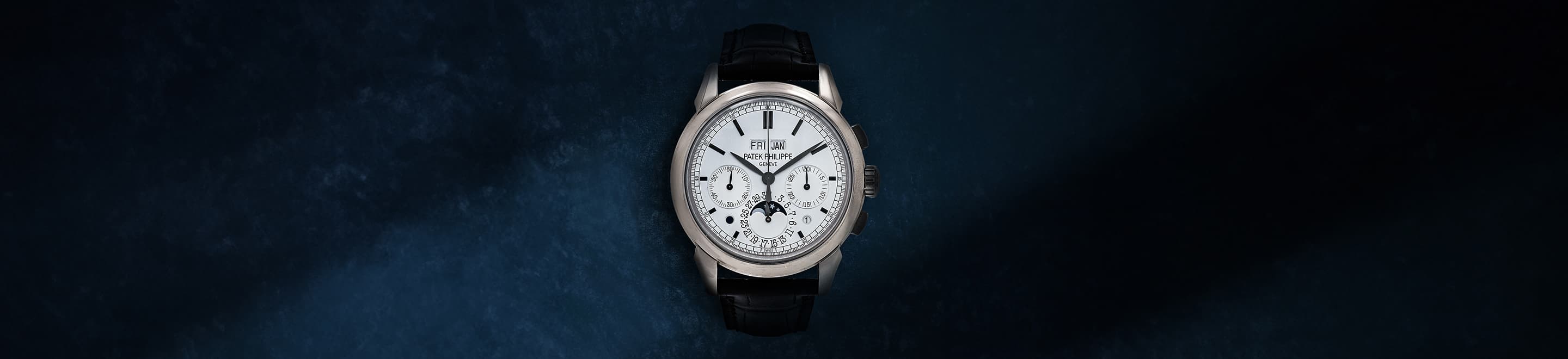 A Patek Philippe wristwatch centred on a dark blue background in Sotheby’s Fine Watches Paris presentation.