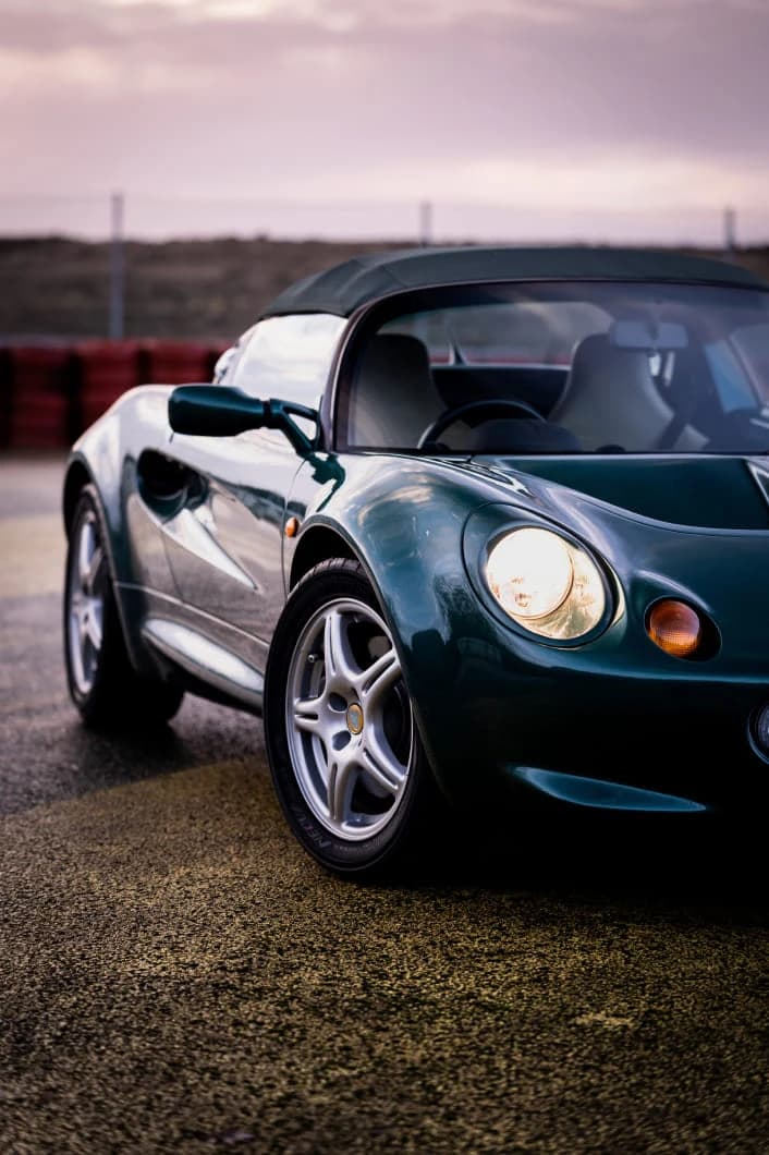 A dark green Series 1 Lotus Elise 111S viewed from the front quarter in an archival maker photograph.
