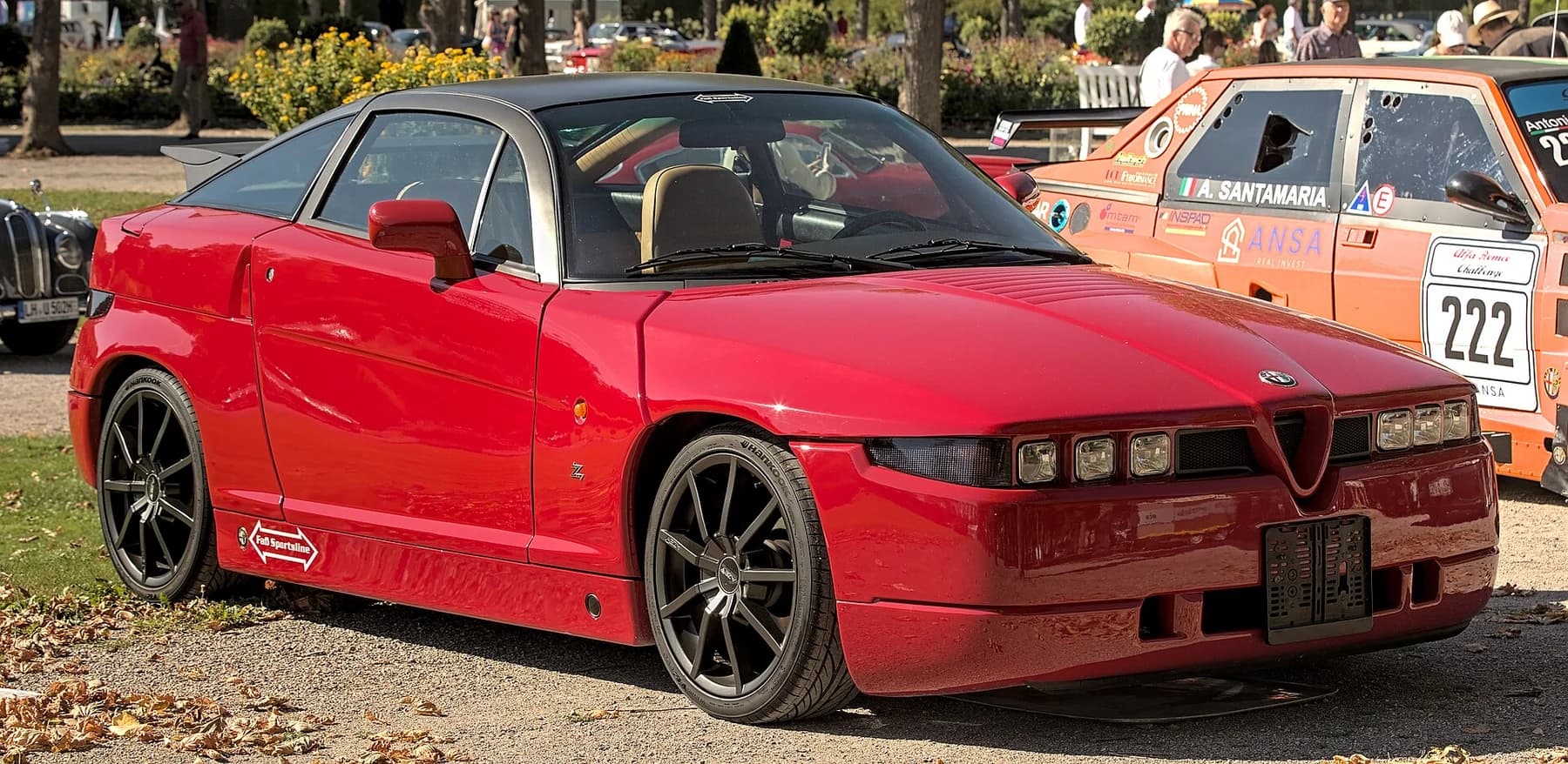 A red Alfa Romeo SZ seen from the front quarter at Classic-Gala 2022, with its triple rectangular headlamps, high beltline, short body and dark roof visible.