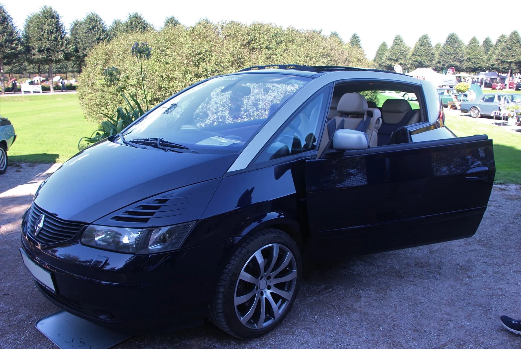 A dark blue Renault Avantime displayed outdoors with its driver’s door open, showing the tall cabin and wide side opening.