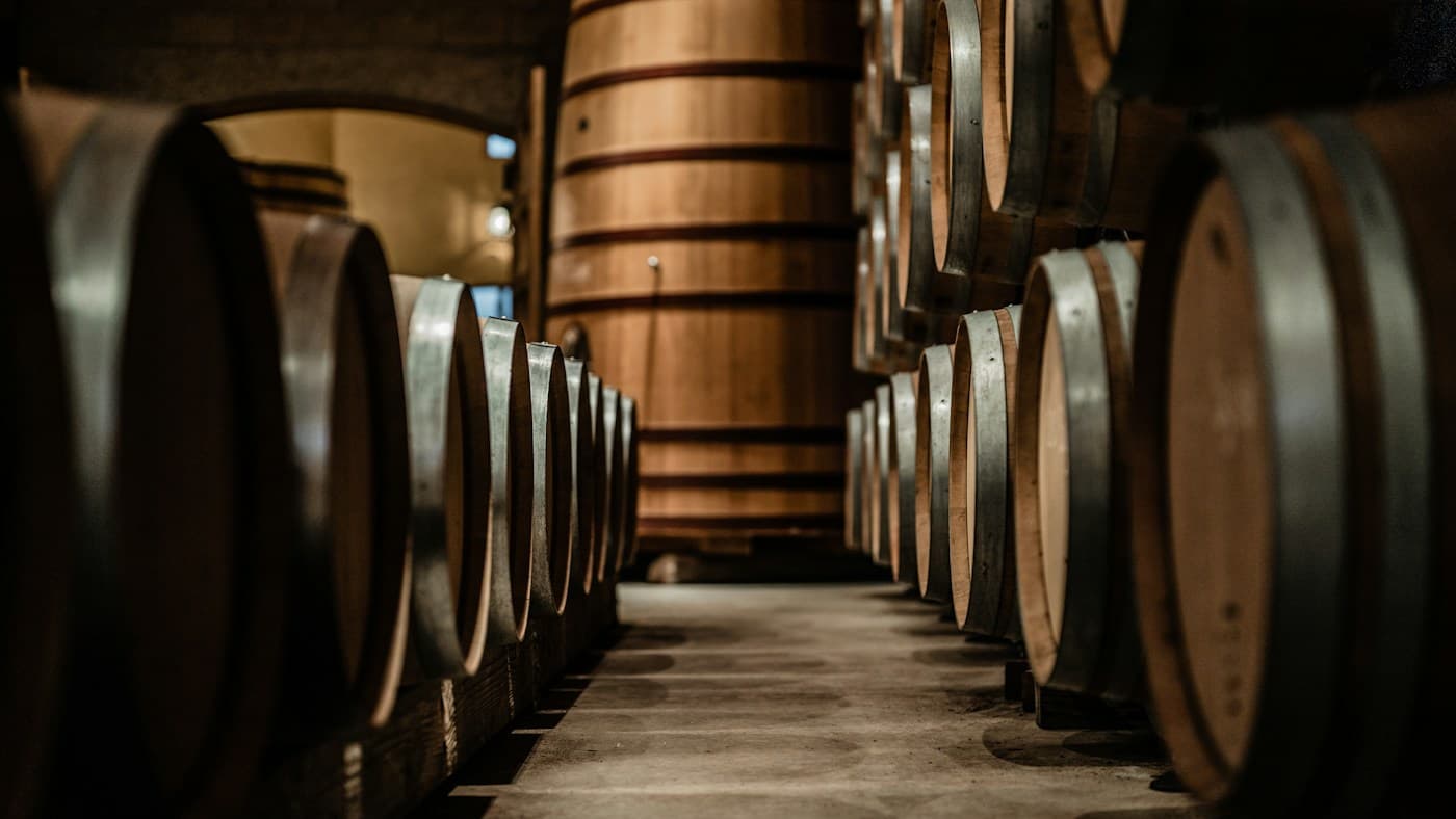Oak barrels arranged in the low-lit cellar of Casa Rondeña Winery.
